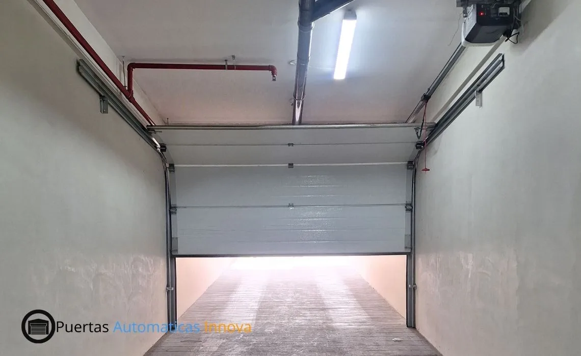Puerta seccional automática con paneles importados y motor LiftMaster instalada para vivienda en San Borja, Lima, por Puertas Automáticas Innova SAC